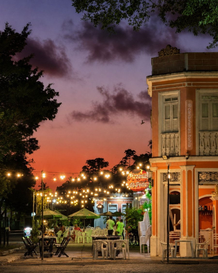 Praça de Canavieiras ao entardecer, com luzes e casario colorido