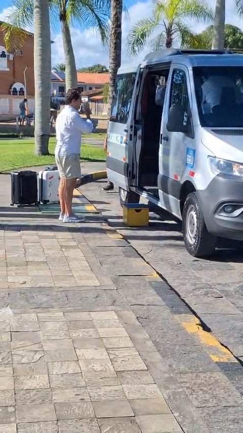 Passageiro carregando malas na van da EVC Turismo, em Comandatuba