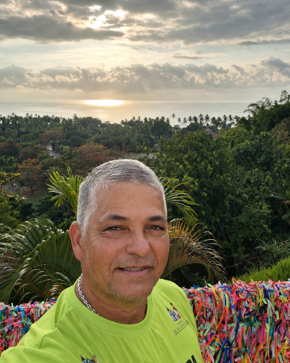 Edson no mirante de Morro de São Paulo, com as fitas coloridas e o mar ao fundo